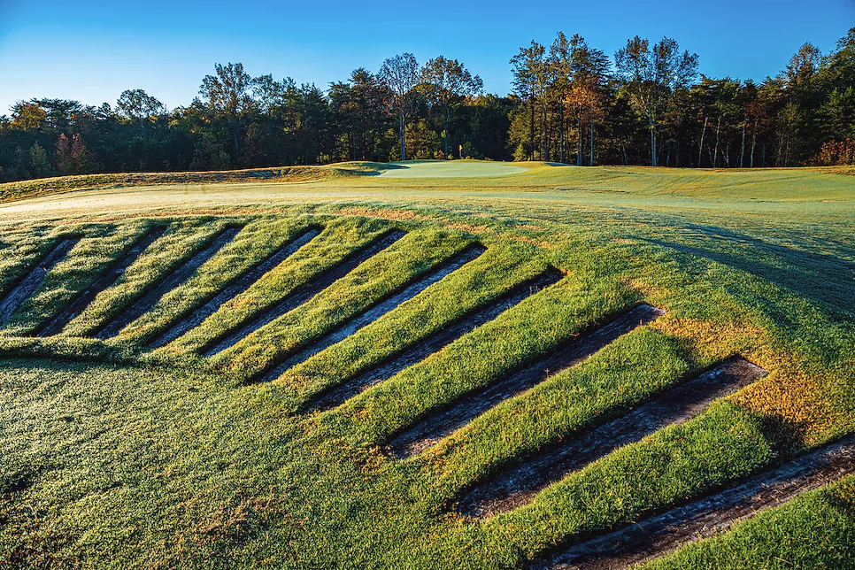 Stacked railroad-tie bunker faces stepping down a hillside at Cutalong, under autumn hardwoods.