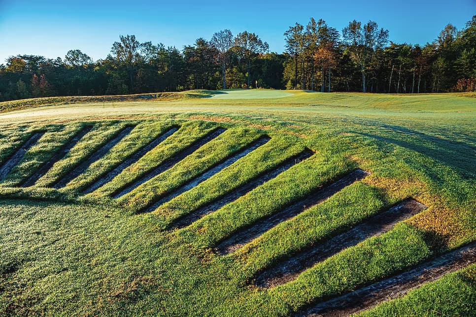 Stacked railroad-tie bunker faces stepping down a hillside at Cutalong, under autumn hardwoods.