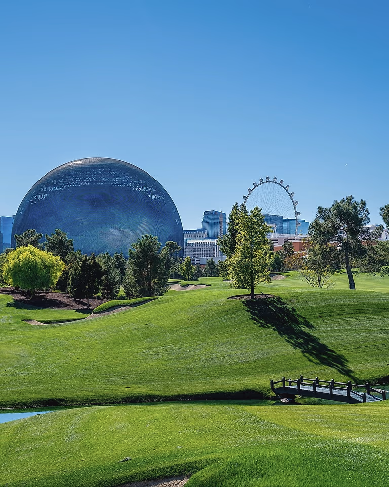 The Sphere rising above the fairway at Wynn Golf Club, with the High Roller wheel and the Las Vegas skyline beyond.